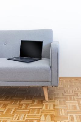 Laptop on the grey couch-stock-photo