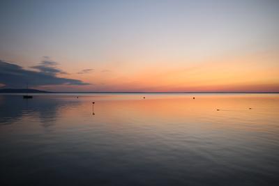Sunrise at lake with sailboat-stock-photo