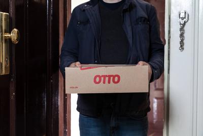 Paketbote liefert ein Otto Paket an die Haust?r *** Parcel carrier delivers an Otto parcel to the front door-stock-photo