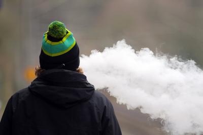 Tabak versus Elektrische Zigarette Ein Mann bl?st den Dampf einer E-Zigarette aus *** Tobacco versus Electric Cigarette-stock-foto