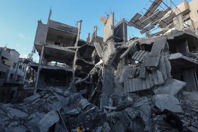 Palestinian residents of the area inspect the targeted building and surrounding structures that sustained damage after Israeli attack on Nuseirat-stock-foto