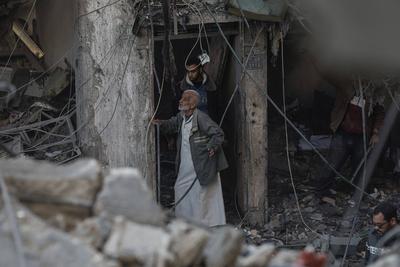 Palestinian residents of the area inspect the targeted building and surrounding structures that sustained damage after Israeli attack on Nuseirat-stock-foto