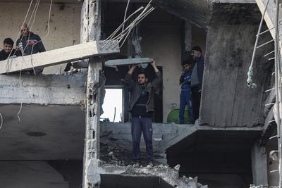 Palestinian residents of the area inspect the targeted building and surrounding structures that sustained damage after Israeli attack on Nuseirat-stock-foto