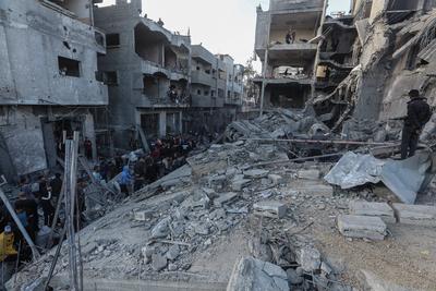 Palestinian residents of the area inspect the targeted building and surrounding structures that sustained damage after Israeli attack on Nuseirat-stock-foto