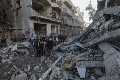 Palestinian residents of the area inspect the targeted building and surrounding structures that sustained damage after Israeli attack on Nuseirat-stock-foto