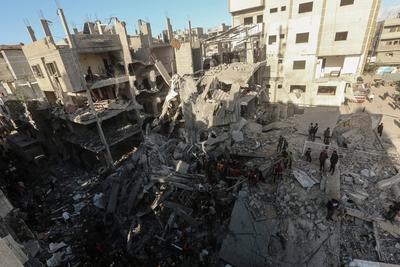 Palestinian residents of the area inspect the targeted building and surrounding structures that sustained damage after Israeli attack on Nuseirat-stock-foto