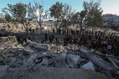 Palestinian residents of the area inspect the targeted building and surrounding structures that sustained damage after Israeli attack on Nuseirat-stock-foto