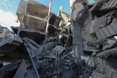 Palestinian residents of the area inspect the targeted building and surrounding structures that sustained damage after Israeli attack on Nuseirat-stock-foto