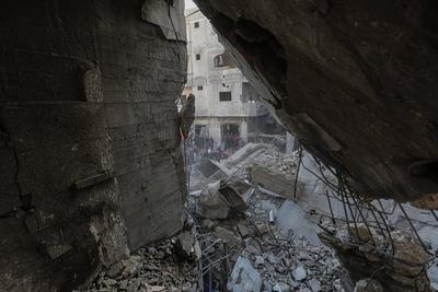 Palestinian residents of the area inspect the targeted building and surrounding structures that sustained damage after Israeli attack on Nuseirat-stock-foto