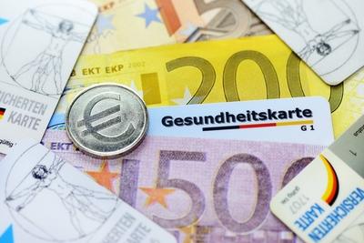 Gesundheitskarte Geldscheine und M?nze mit Eurozeichen Erh?hung der Krankenkassenbeitr?ge-stock-foto