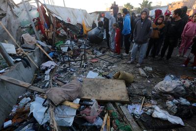 Palestinians inspect the damaged area following an Israeli attack on tents housing the displaced Palestinians in Deir al-Balah-stock-foto
