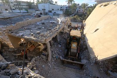Palestinian residents and civil defense teams conduct a search and rescue operation in the Deir al-Balah-stock-photo