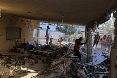 Palestinian residents and civil defense teams conduct a search and rescue operation in the Deir al-Balah-stock-photo