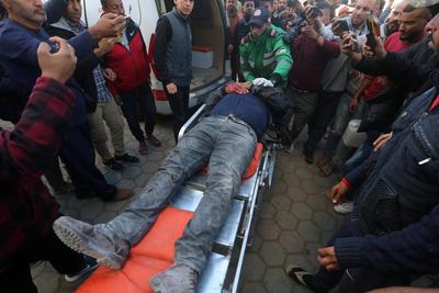 People transport the bodies and injured Palestinians to Al-Aqsa Martyrs Hospital after an Israeli air strike targeted the Deir al-Balah municipality-stock-photo