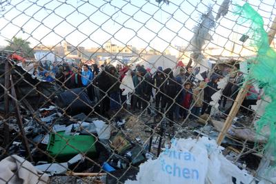 Palestinians inspect the damaged area following an Israeli attack on tents housing the displaced Palestinians in Deir al-Balah-stock-foto