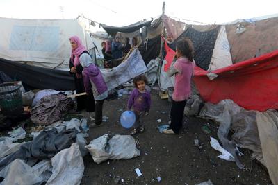Palestinians inspect the damaged area following an Israeli attack on tents housing the displaced Palestinians in Deir al-Balah-stock-foto