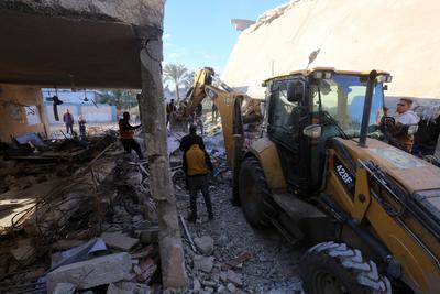 Palestinian residents and civil defense teams conduct a search and rescue operation in the Deir al-Balah-stock-photo