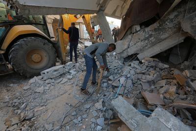 Palestinian residents and civil defense teams conduct a search and rescue operation in the Deir al-Balah-stock-photo