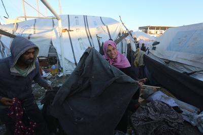 Palestinians inspect the damaged area following an Israeli attack on tents housing the displaced Palestinians in Deir al-Balah-stock-foto