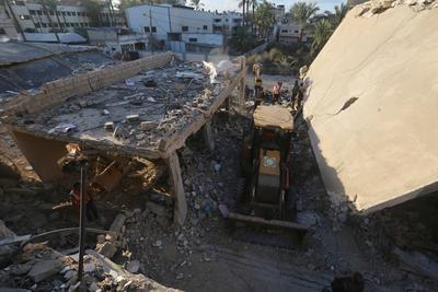 Palestinian residents and civil defense teams conduct a search and rescue operation in the Deir al-Balah-stock-photo