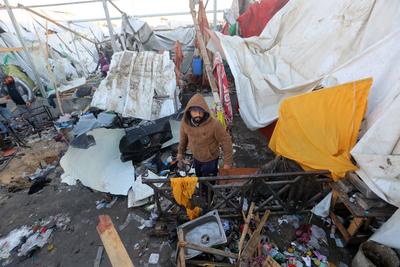 Palestinians inspect the damaged area following an Israeli attack on tents housing the displaced Palestinians in Deir al-Balah-stock-foto