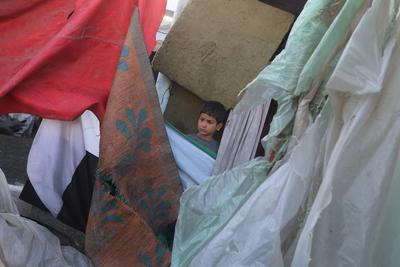 Palestinians inspect the damaged area following an Israeli attack on tents housing the displaced Palestinians in Deir al-Balah-stock-foto