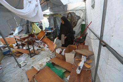Palestinians inspect a destroyed field medical clinic, after an Israeli air strike on displaced people's tents-stock-foto