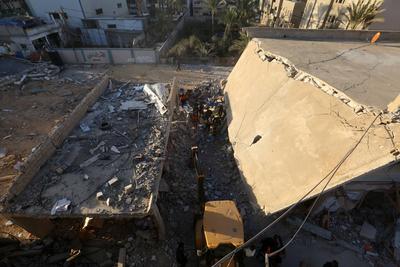 Palestinian residents and civil defense teams conduct a search and rescue operation in the Deir al-Balah-stock-photo