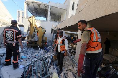 Palestinian residents and civil defense teams conduct a search and rescue operation in the Deir al-Balah-stock-photo