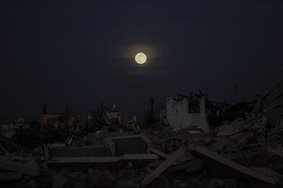 A full moon rises over destroyed buildings in the Zawaida eara in the central of Gaza Strip early-stock-foto