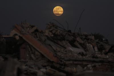 A full moon rises over destroyed buildings in the Zawaida eara in the central of Gaza Strip early-stock-foto