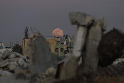 A full moon rises over destroyed buildings in the Zawaida eara in the central of Gaza Strip early-stock-foto