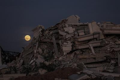 A full moon rises over destroyed buildings in the Zawaida eara in the central of Gaza Strip early-stock-foto