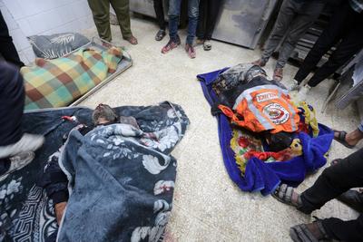 Palestinians and civil defense personnel transfer a number of martyrs and wounded to Al-Aqsa Martyrs Hospital after an Israeli air strike targeted a point belonging to civil defense crews in the Nuseirat-stock-foto