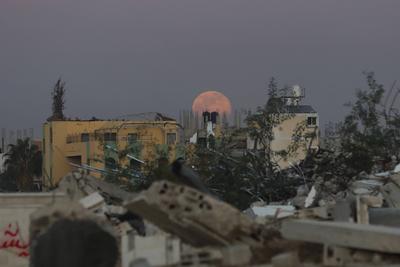 A full moon rises over destroyed buildings in the Zawaida eara in the central of Gaza Strip early-stock-foto