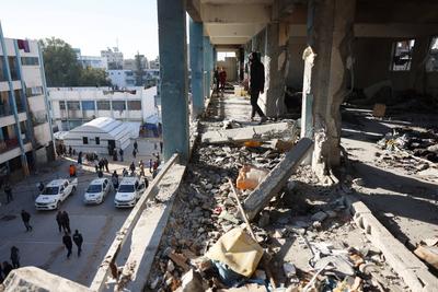 Palestinians inspect the damage in the aftermath of an Israeli strike on a school sheltering displaced people, amid the Israel-Hamas conflict, in Khan Younis-stock-foto