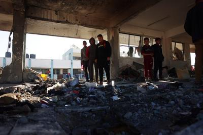 Palestinians inspect the damage in the aftermath of an Israeli strike on a school sheltering displaced people, amid the Israel-Hamas conflict, in Khan Younis-stock-foto