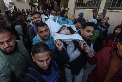 Palestinian journalists mourn the body of Al Jazeera cameraman Ahmed Al-Louh at Al-Awda Hospital, who was martyred as a result of an Israeli bombardment of the Civil Defense headquarters in the Nuseirat-stock-photo