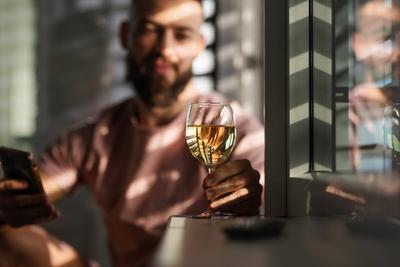 Young man looking at glass with white wine, New Year s resolutions, drink less alcohol healthy lifestyle without alcohol-stock-foto