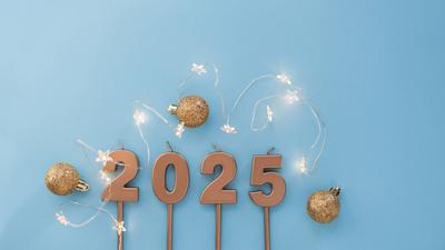 Goldene festliche Kerzen 2025 mit Lichtern Sterne liegen mit goldenen Kugeln auf einem blauen Hintergrund. Feiertage Tap-stock-photo