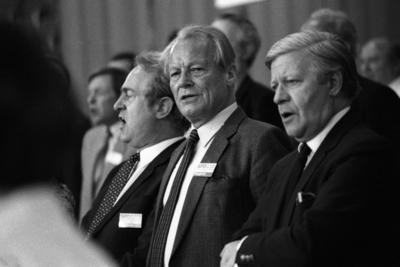 Bildnummer: 51971072  Datum: 20.04.1982  Copyright: imago/SommerWacht auf, Verdammte dieser Erde: V.l.n.r.: Johannes Rau (GER/SPD/Ministerpr?sident Nordrhein-Westfalen), Willy Brandt (GER/SPD-Bundesvorsitzender) und Bundeskanzler Helmut Schmidt (GER/SPD) singen die Internationale auf dem Bundesparteitag der SPD in M?nchen, Personen; 1982, M?nchen, sw, Parteitag, Bundesparteitag , Politiker,   Landesregierung, Landespolitik, Gestik; , quer, Kbneg, Gruppenbild, close, Parteien, Politik, Deutschland, Randbild, People-stock-foto