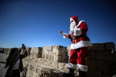 Christmas preparations in Jerusalem JERUSALEM - DECEMBER 19: Christian Palestinian Issa Kassissieh, dressed as Santa Cla-stock-photo
