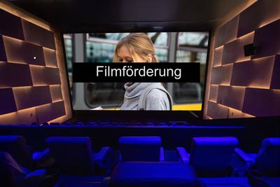 Symbolbild Filmf?rderung: Text FILMF?RDERUNG auf der Leinwand in einem Kinosaal (Composing, Model released) *** Symbolic-stock-photo