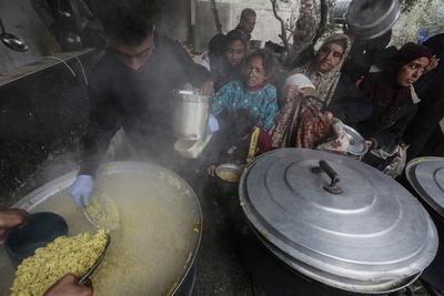 Palestinians gather to receive food cooked by a charity kitchen amid a hunger crisis as the Israel-Gaza-stock-foto