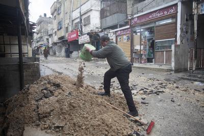 Palestinians inspect the destruction after Israeli army construction equipment digs roads and damages-stock-foto