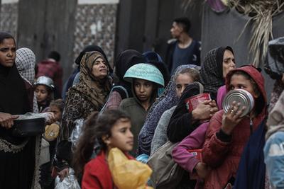 Palestinians gather to receive food cooked by a charity kitchen amid a hunger crisis as the Israel-Gaza-stock-foto