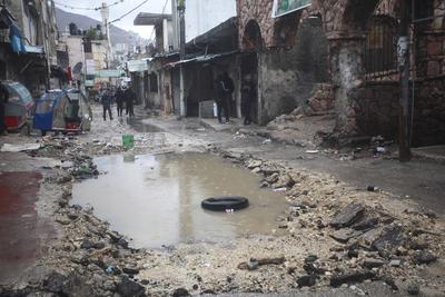Palestinians inspect the destruction after Israeli army construction equipment digs roads and damages-stock-foto