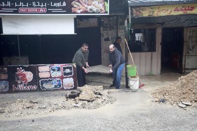 Palestinians inspect the destruction after Israeli army construction equipment digs roads and damages-stock-foto