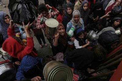 Palestinians gather to receive food cooked by a charity kitchen amid a hunger crisis as the Israel-Gaza-stock-foto