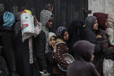 Palestinians gather to receive food cooked by a charity kitchen amid a hunger crisis as the Israel-Gaza-stock-foto